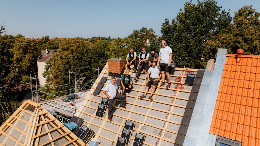 Gruppe von Dachdeckern auf einem ungedeckten Hausdach